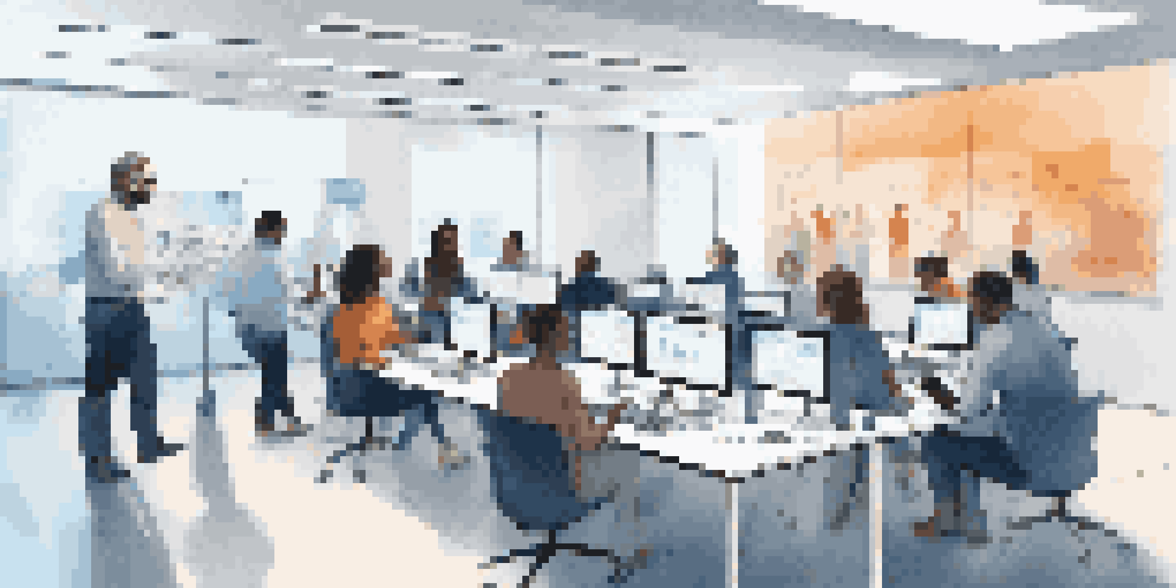 A diverse group of participants engaged in user testing in a modern room, with laptops and tablets, and a large screen displaying software.