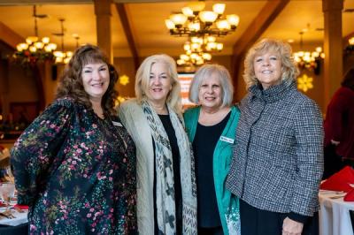 Four founding Women Build Committee volunteers at the Holiday Luncheon and Auction
