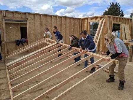 Volunteers raising a wall on a Women Build day on Habitat's construction site 