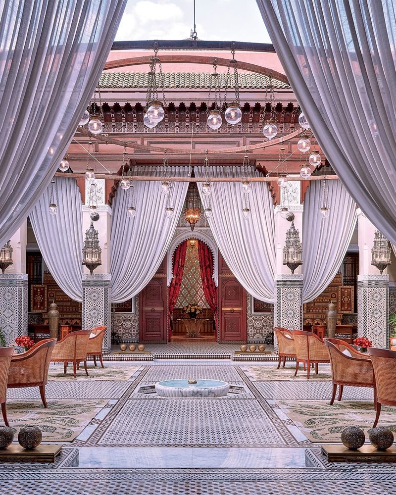 Riad courtyard with silver drapes and a tiled fountain