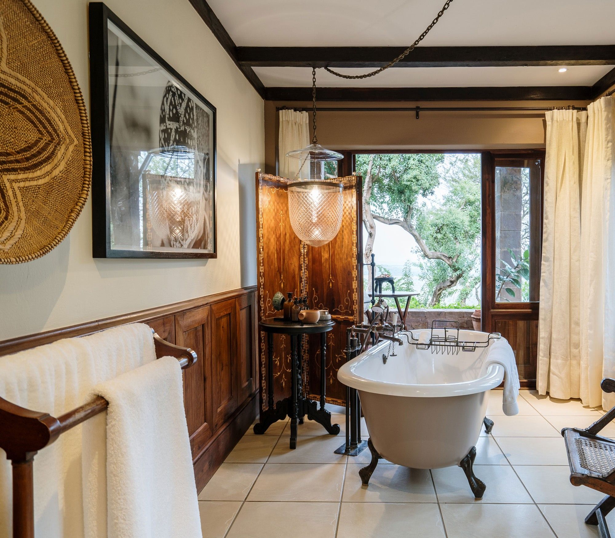 A suite bathroom with savannah views at Singita Grumeti