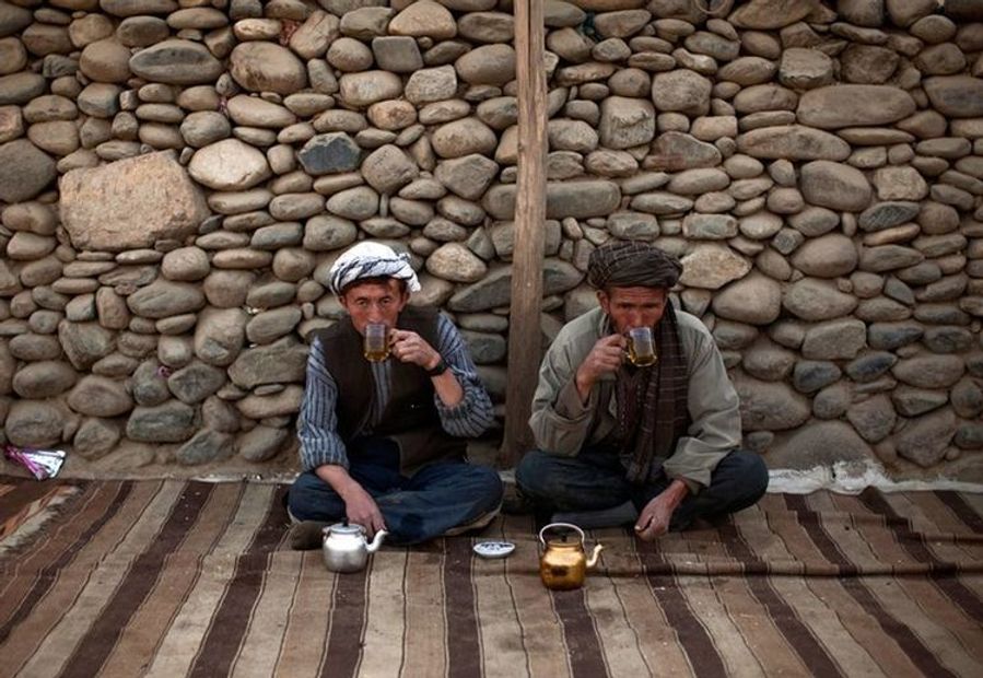 Two Afghan travellers meet for tea