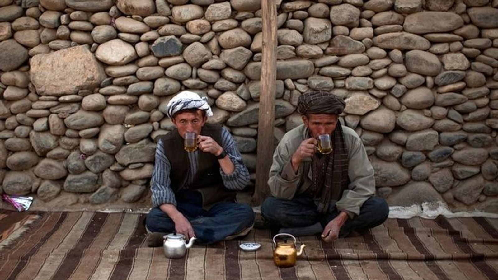 Two Afghan travellers meet for tea