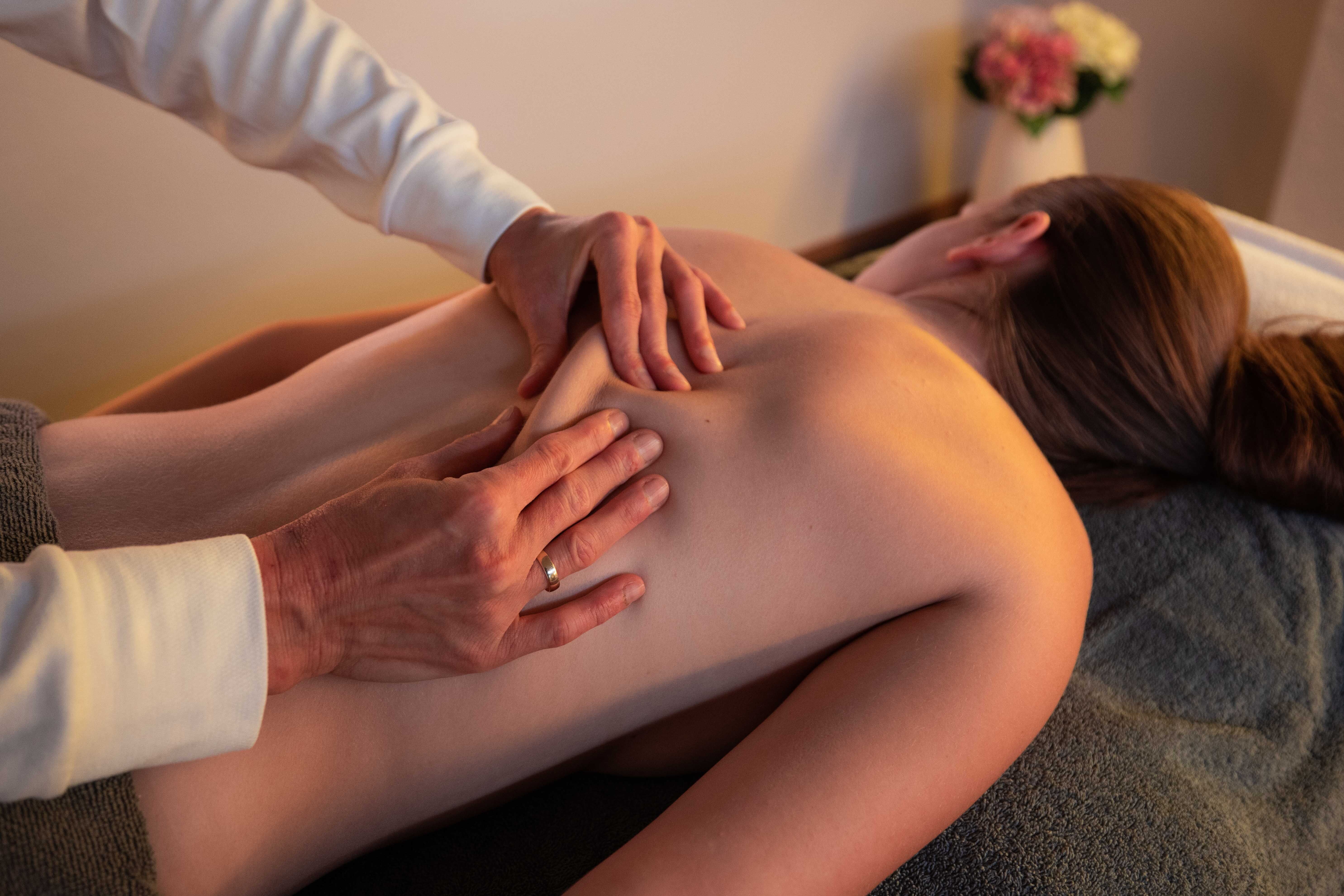 Hände einer Therapeutin bei einer Deep Tissue Massage