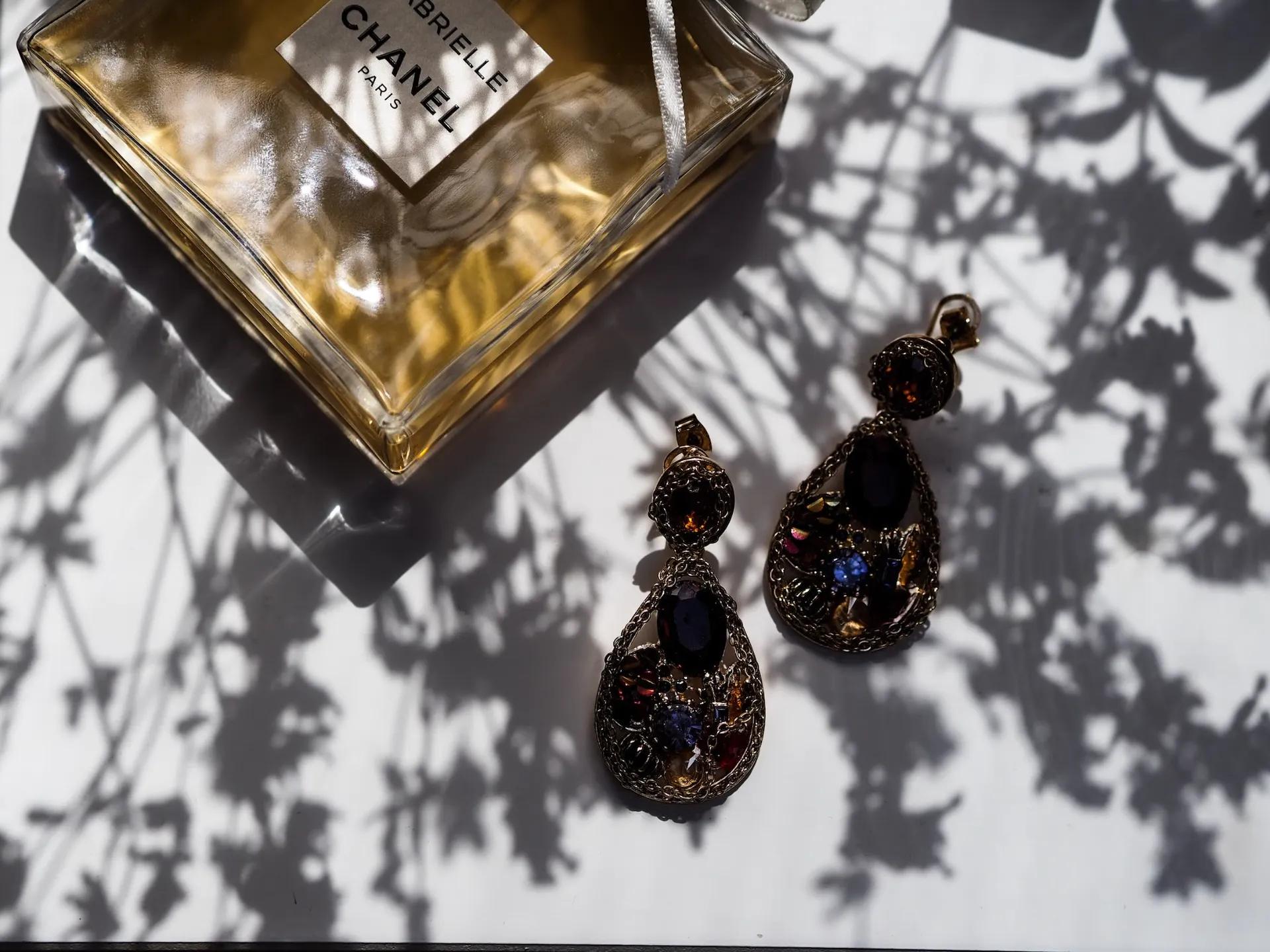 A bottle of perfume and a pair of earings