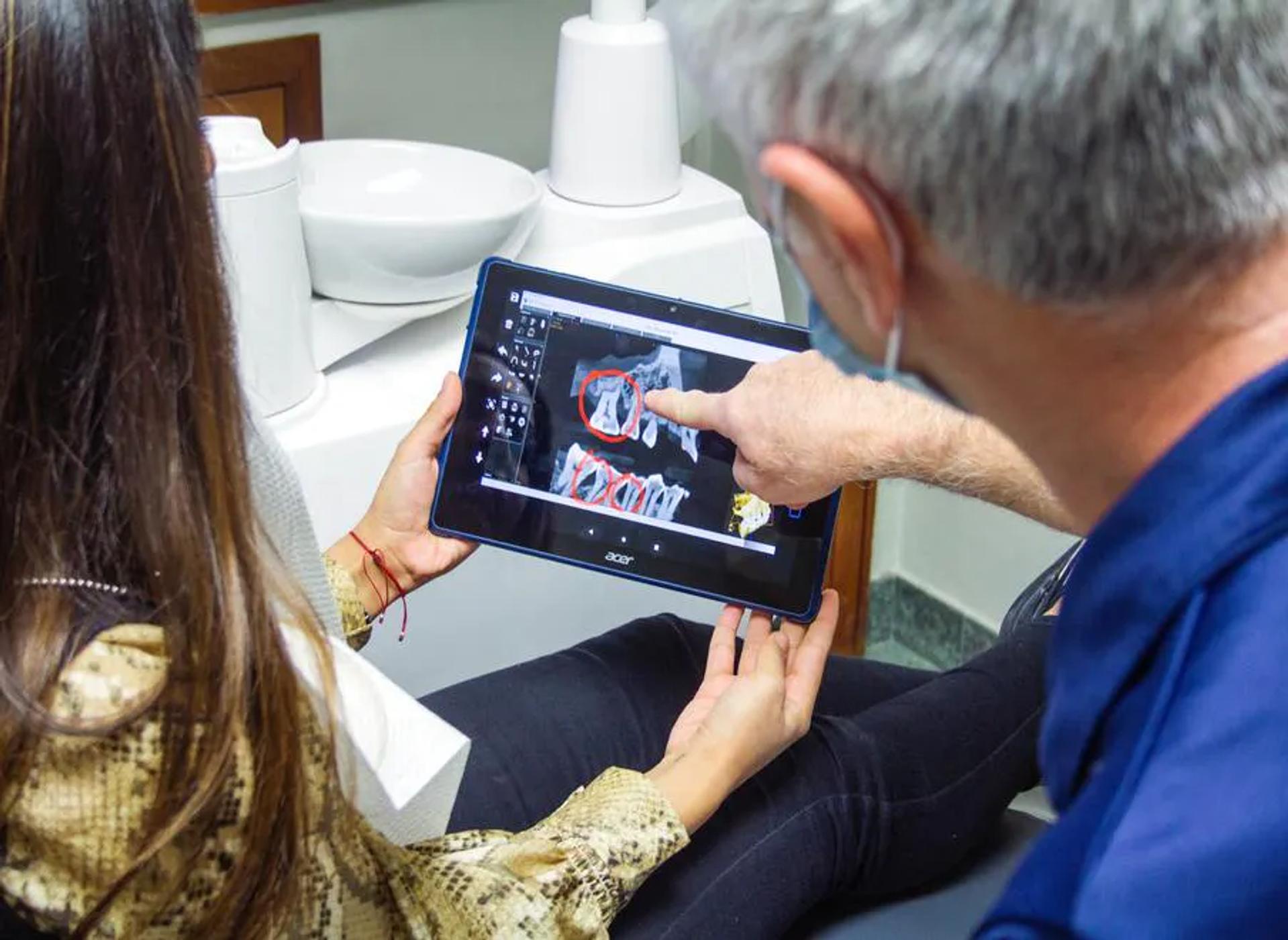 A doctor and patient looking at an x-ray on a tablet