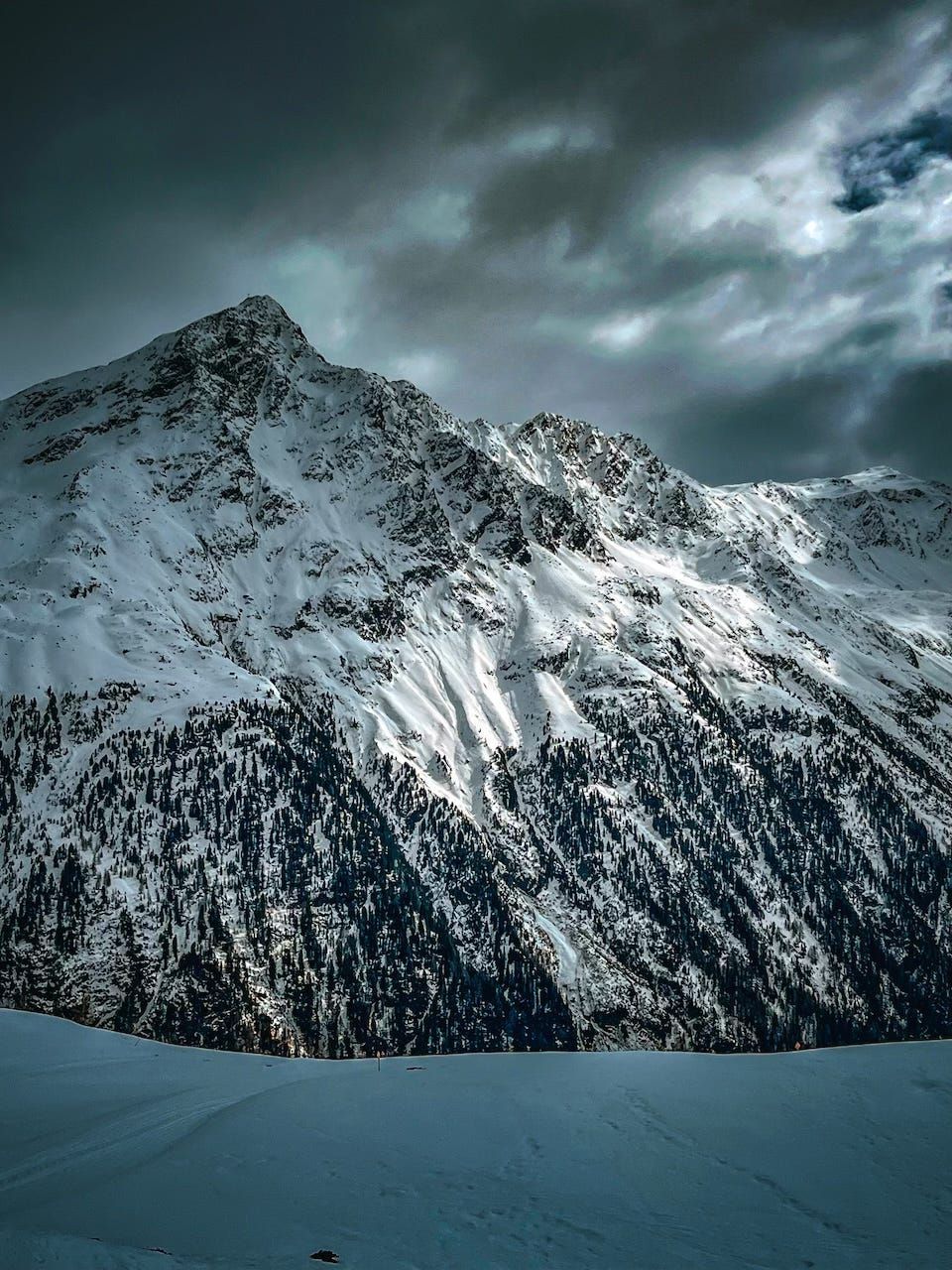 A snowy mountain with clouds in the sky
AI-generated content may be incorrect.