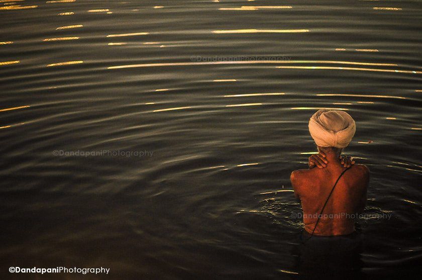 A Sikh man bathes in the man-made pond that surrounds the Golden Temple.