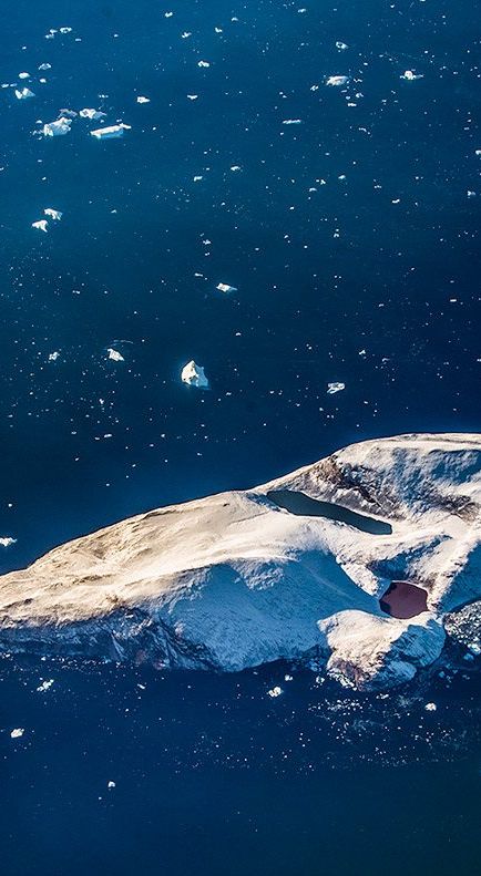 More chunks of ice can be seen in the water as we approach the North Pole. An island with a lake on it.