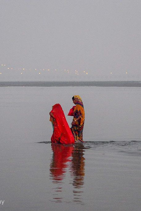 3 women walk across some of the shallowers parts of the river