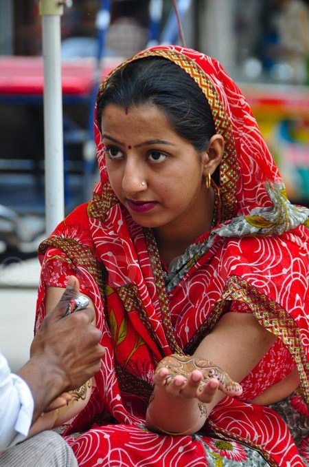 Girl gets henna done on her hands by an artists