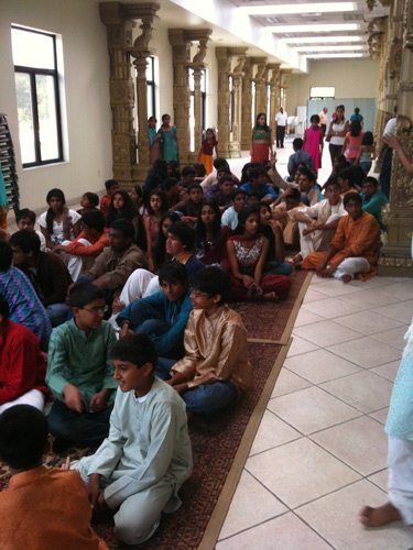 They gather in one of the temple hallways to sing bhajans. They practice every night and sound really good.
