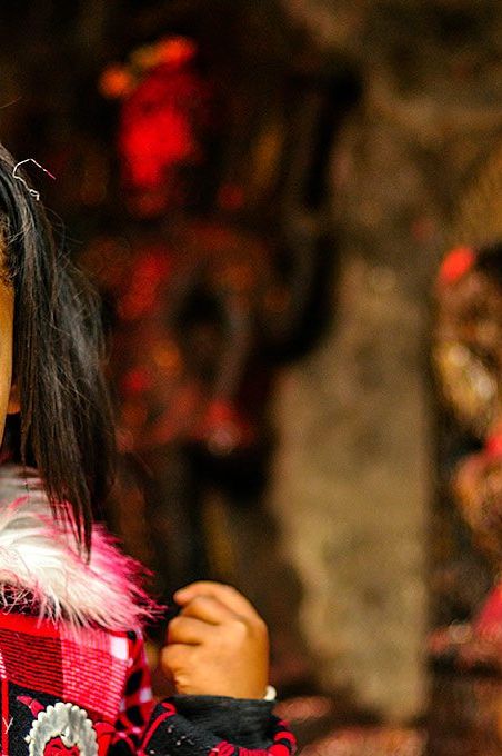 A young girl prays to a statue of Ganesha at a small shrine in Kathmandu, Nepal.