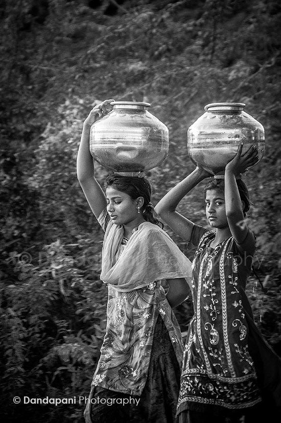 Young girls fetch water from the village well at dawn. Chandelao, Rajasthan.