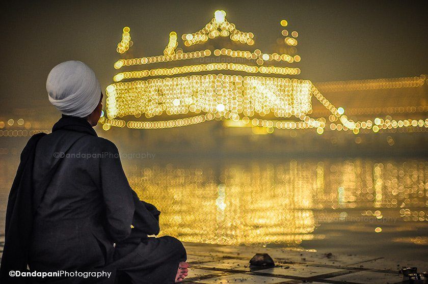 A lady meditates with the Golden Temple, Sri Harmandir Sahib, in the background.