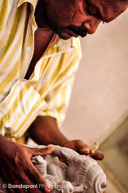 A stone carver in the fishing village of Mamallapuram in South India puts the final touches on a stone Ganesha statue.
