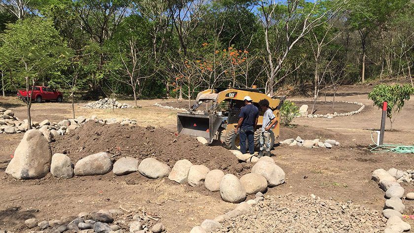 Large flower mounds filled with soil and circled with rocks