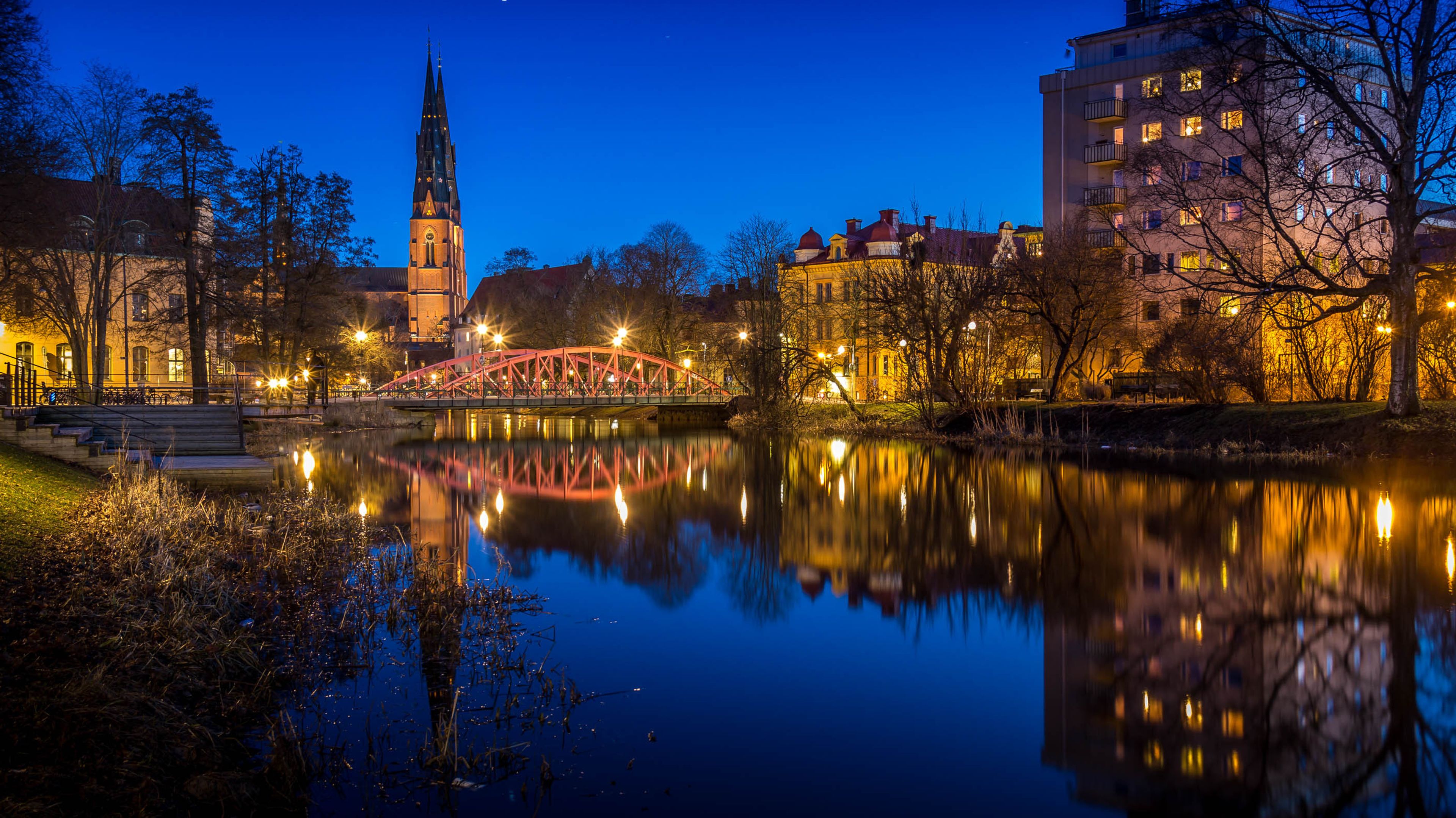 Evening lights of a bridge, the cathedral and parts of Uppsala from across the water