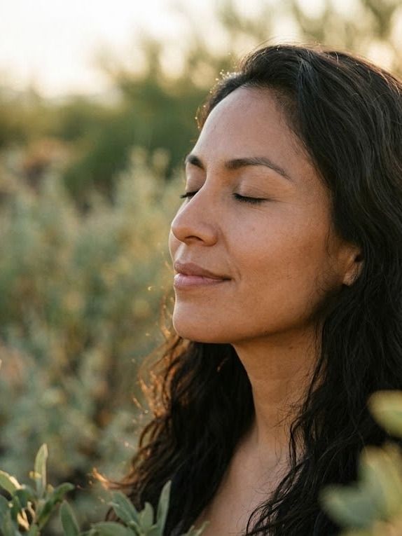 Mujer con los ojos cerrados al sol, respirando con calma