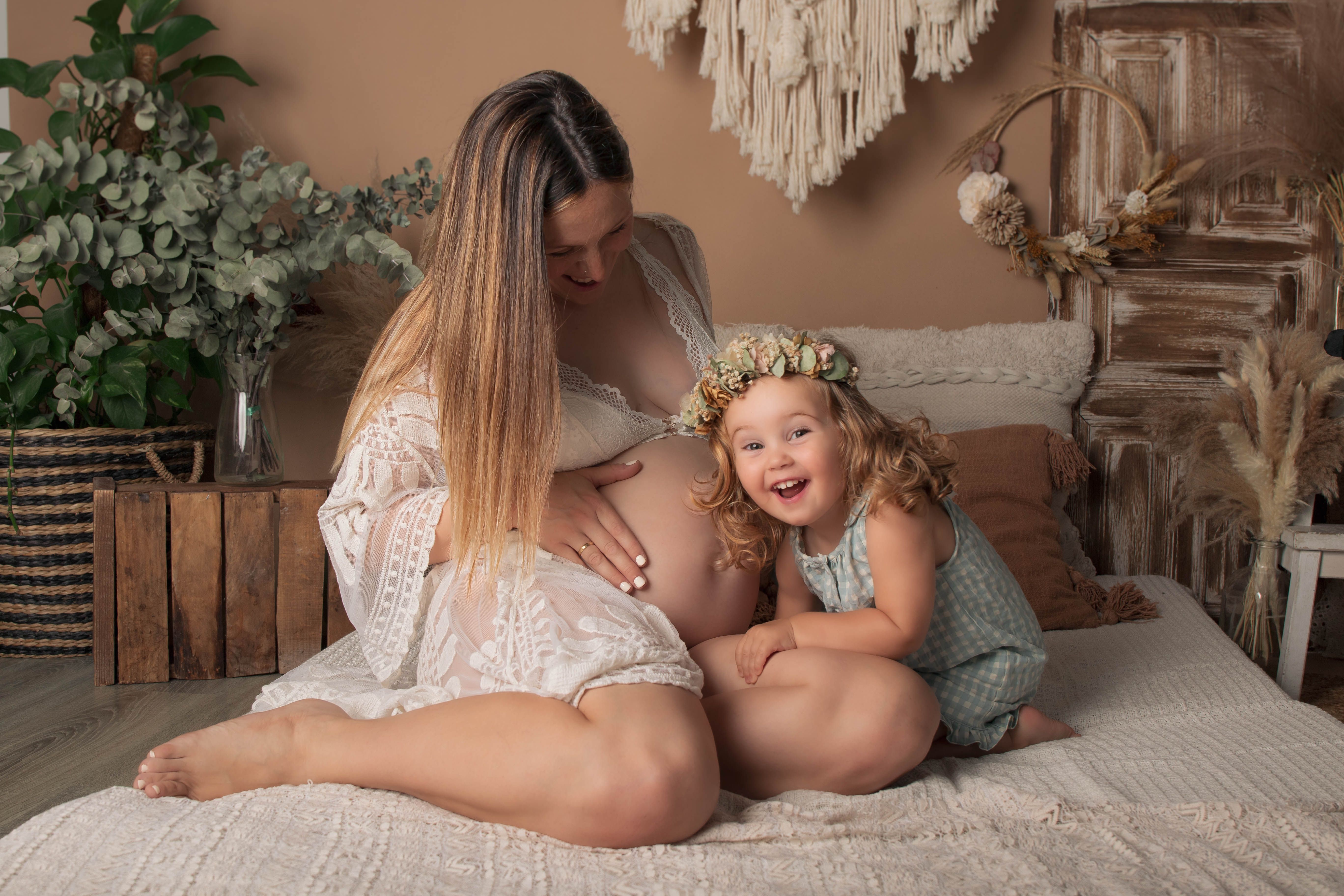 Foto en escenario boho, embarazada y hermanita