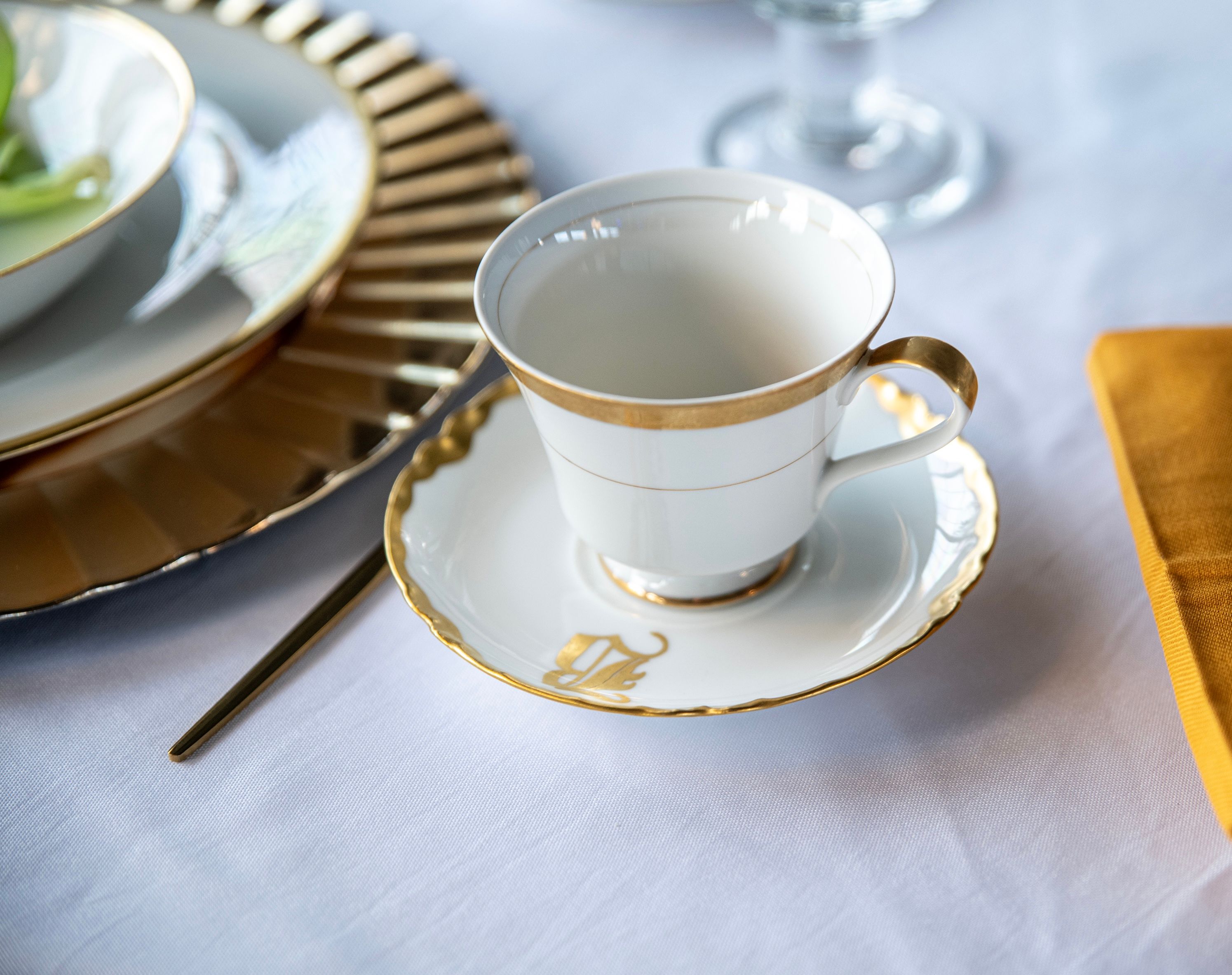 White and gold teacup and fluted saucer place setting