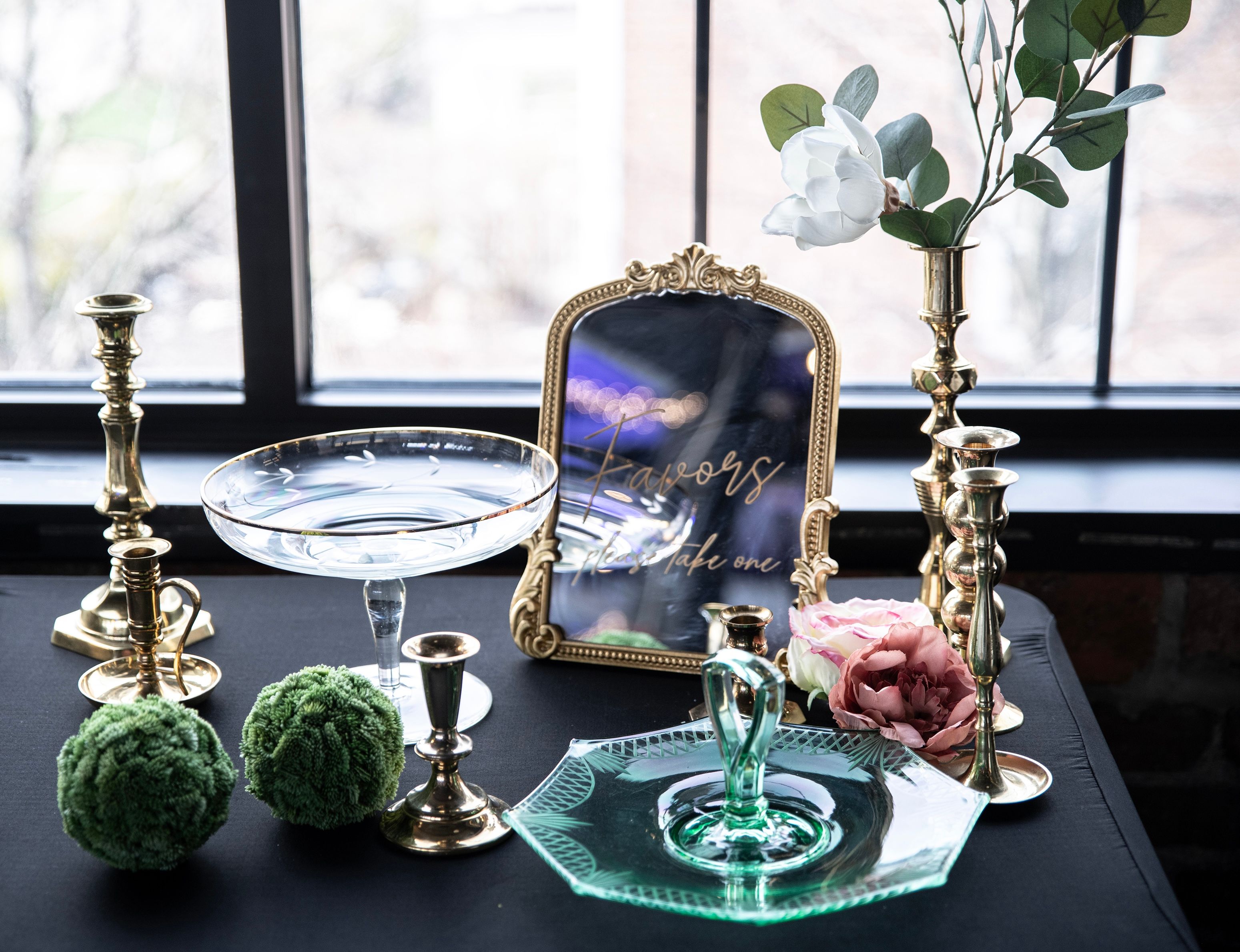 Vintage favors display table with brass candlesticks and green glass tray