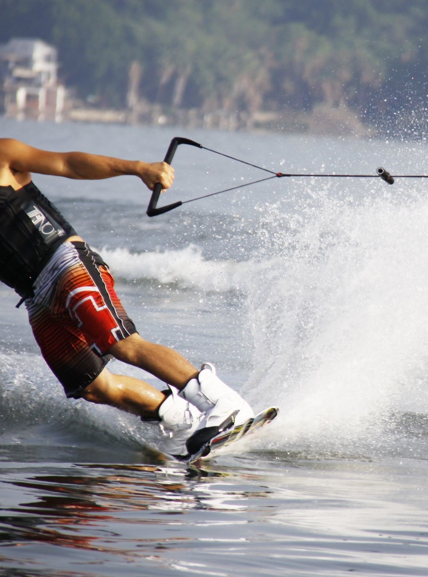 Wakeboarder gliding across the water's surface, performing a turn while being pulled by a cable