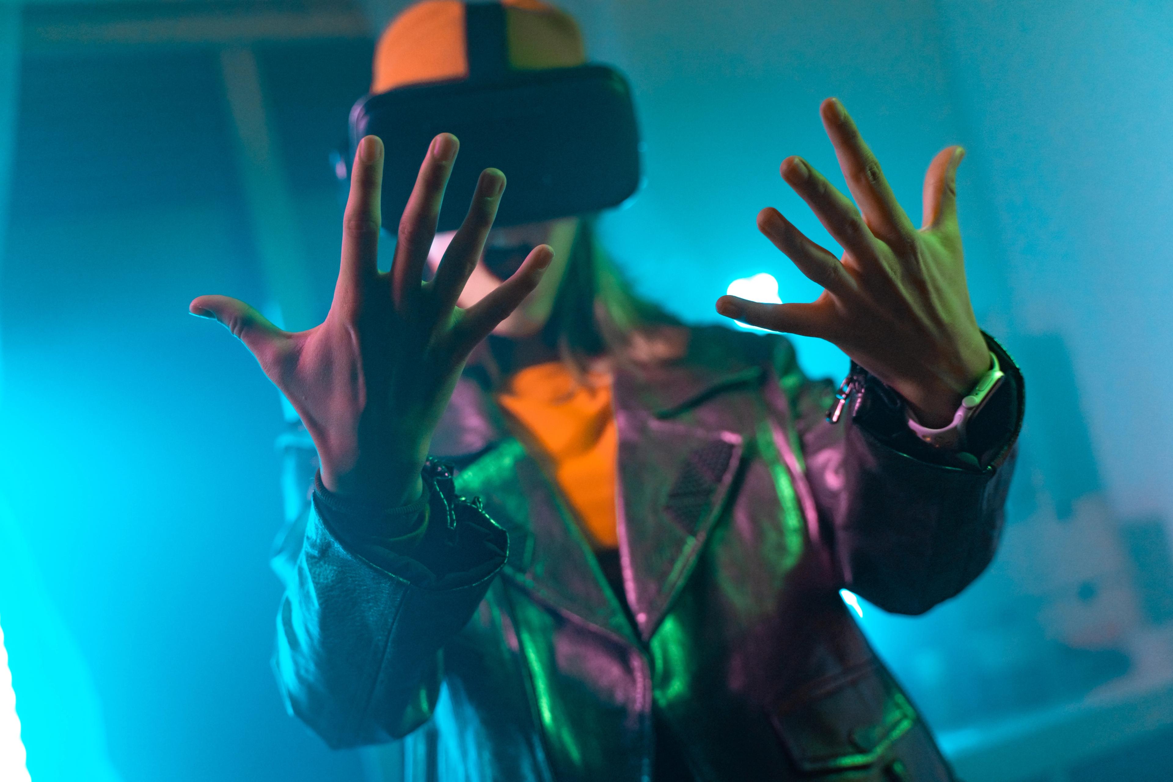 Person wearing a VR headset, immersed in a virtual reality experience, with hands raised in focus