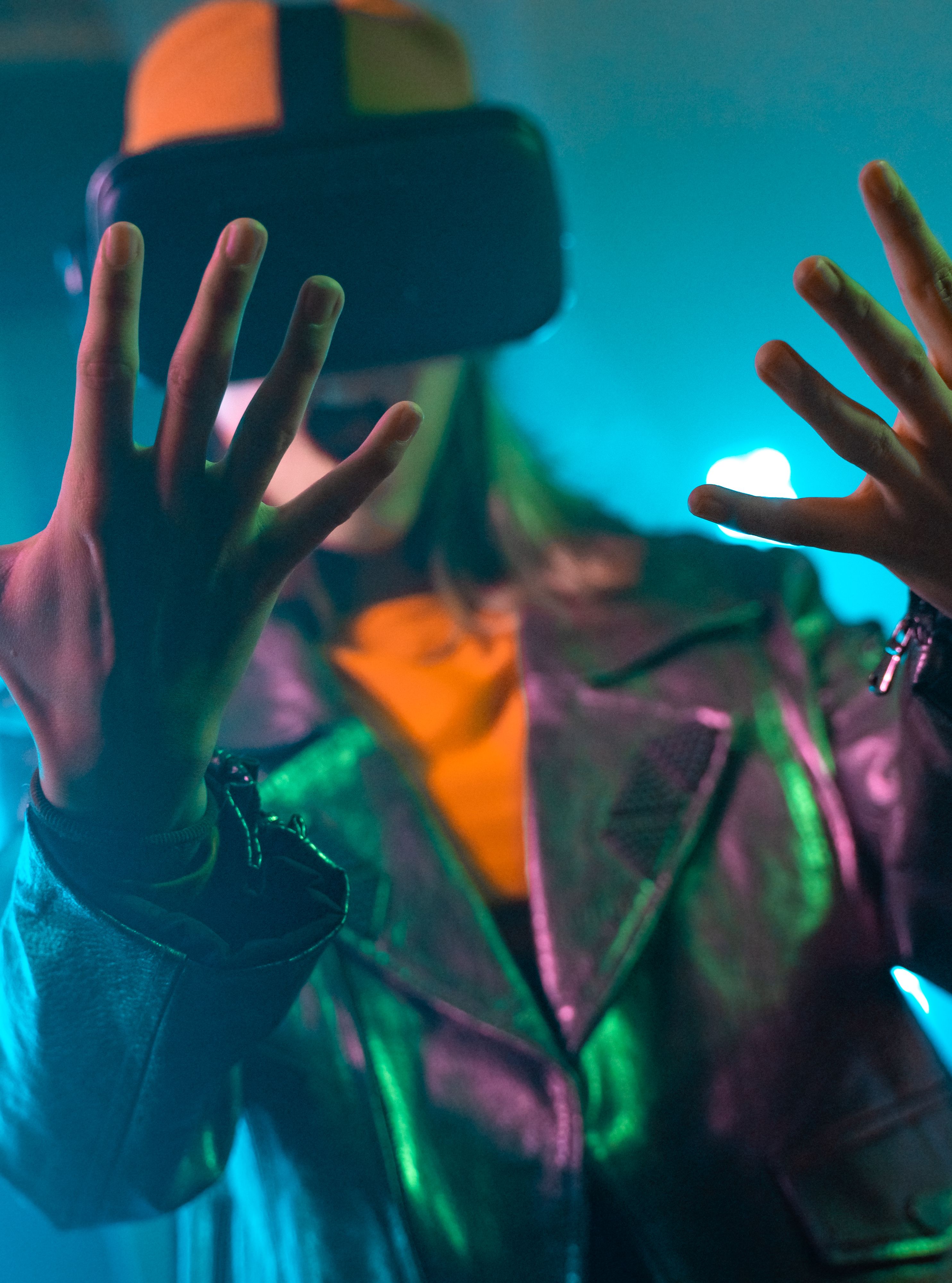 Person wearing a VR headset, immersed in a virtual reality experience, with hands raised in focus
