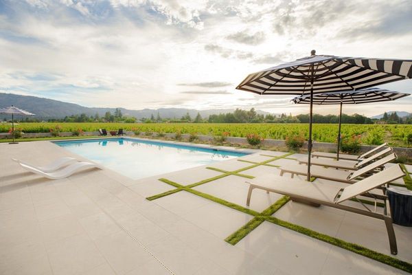 Pool terrace with striped umbrellas and grass joints in the paving