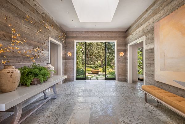 Gallery hall with reclaimed wood walls and a stone floor