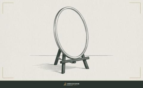 Antique engraving illustration. An empty oval mirror stands upright on a wooden easel, its glass facing the viewer across a bare tabletop.