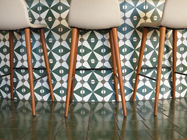 Patterned cement tile floor with wood bar stools