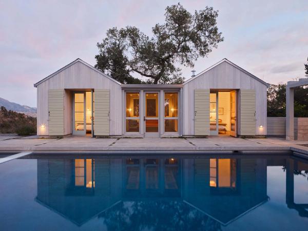 Pool house at dusk reflected in a still pool