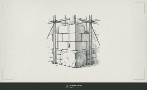 Antique engraving illustration. A cornerstone already set in a rising wall with a fresh course of masonry being added above it, plumb line hanging taut alongside.