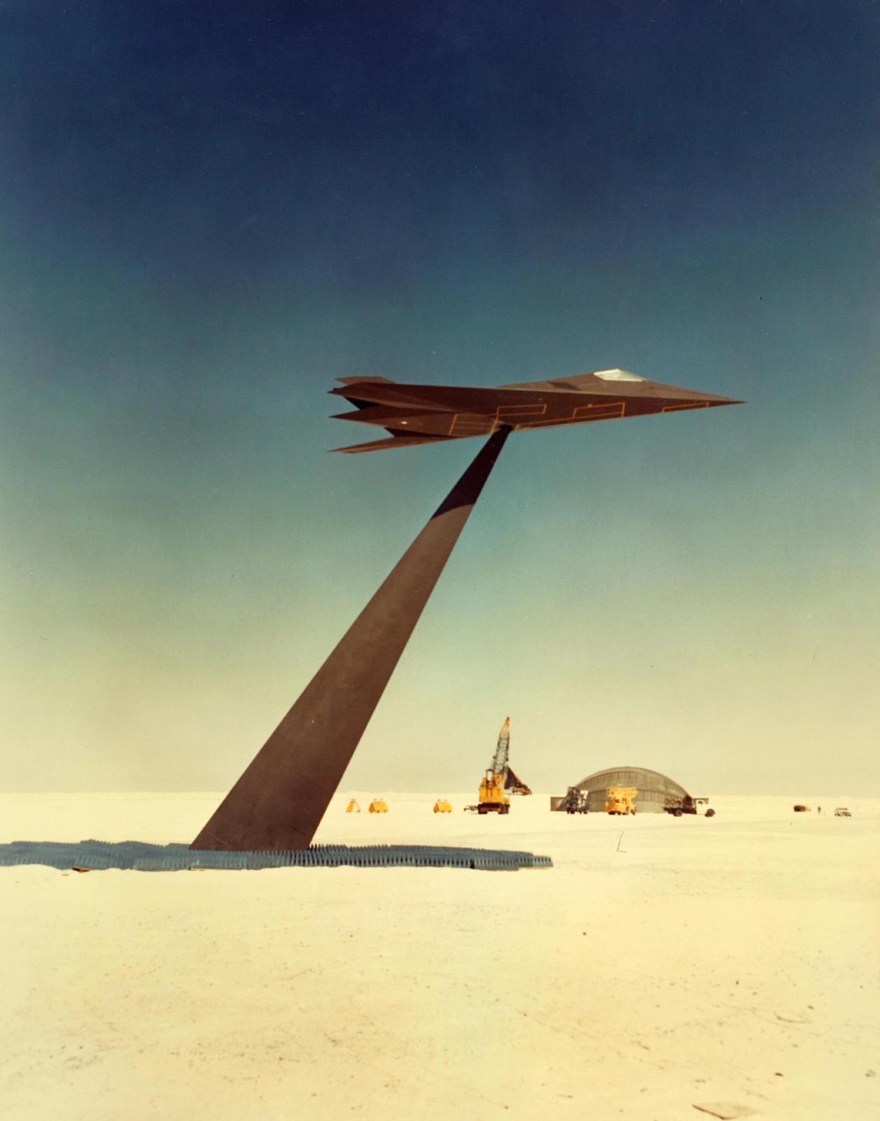 Futuristic scene with angular metallic structure in desert landscape under gradient blue-yellow sky