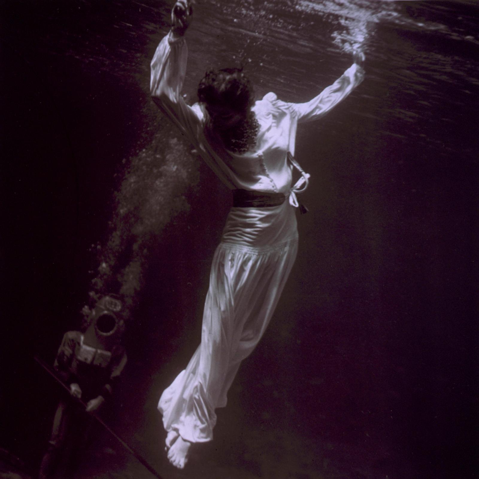 Fashion model underwater with diver in dolphin tank, Marineland, Florida