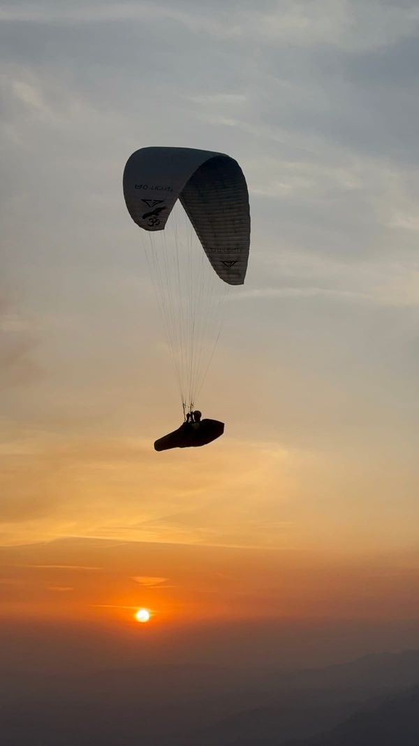 Paraglider silhouette at golden hour over Bir Billing