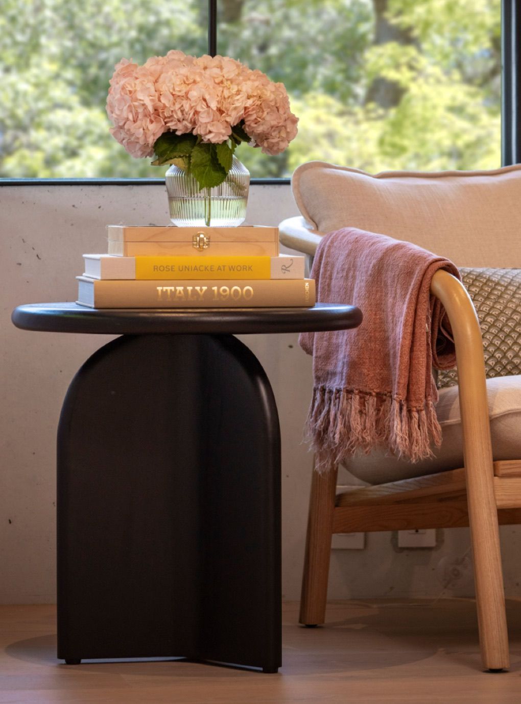 Side table with books and florals by AKIN TO- an interior design studio located in San Francisco with a global focus.