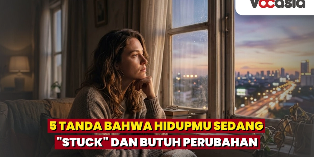 Potret seorang wanita duduk merenung menatap ke luar jendela kota saat senja, merepresentasikan perasaan hidup terasa stuck.