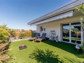 Terrasse mit Rasen und Liegestühlen