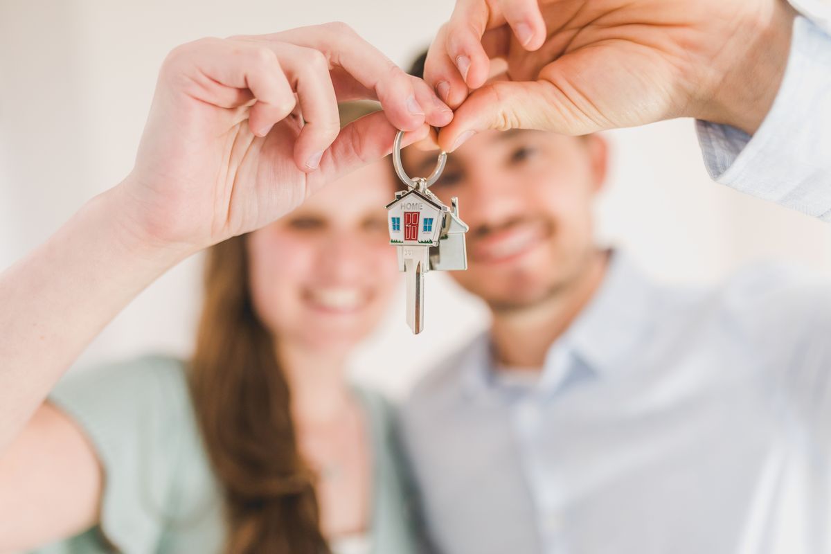 Couple holding up a house key on a keyring