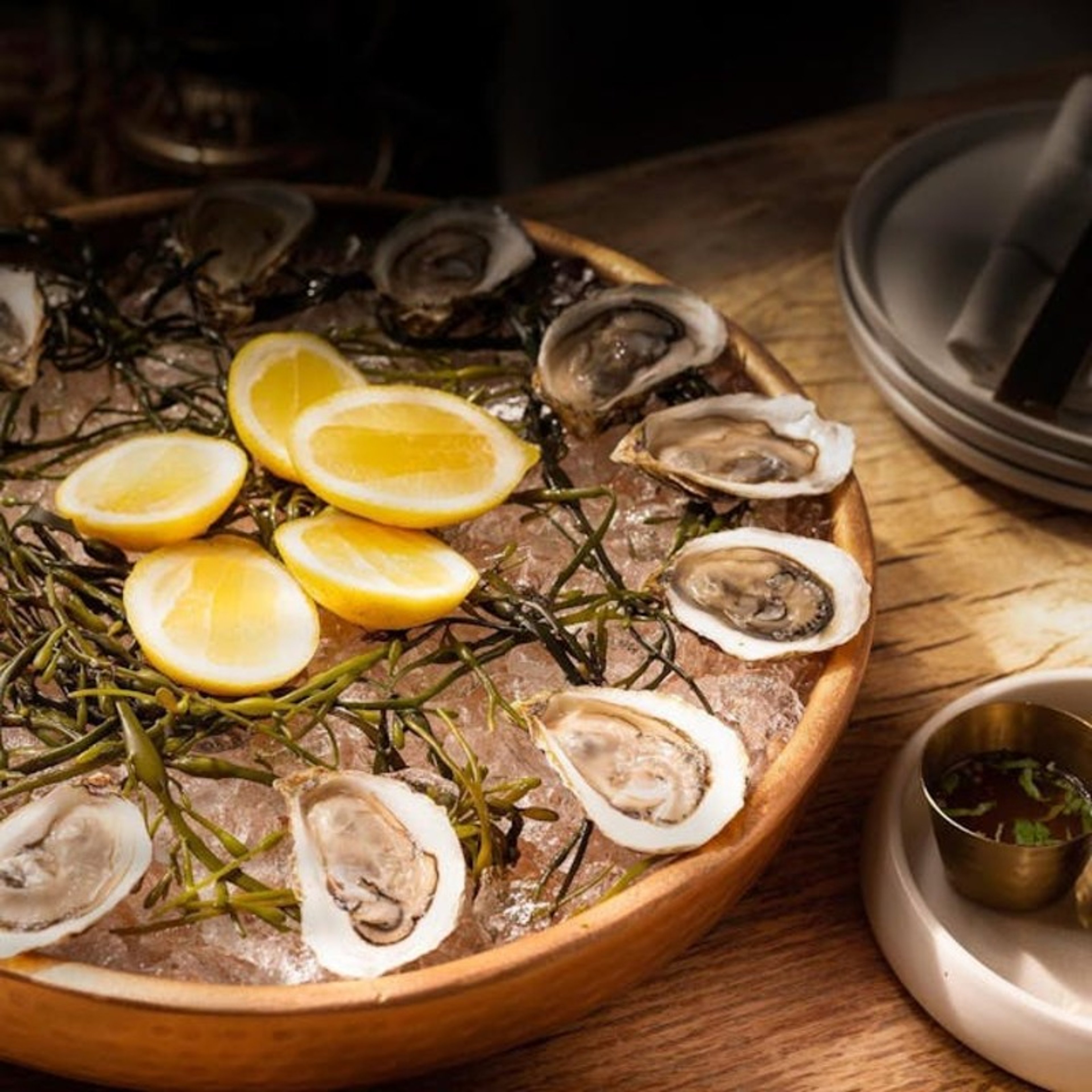 A plate of oysters, with sliced lemons in the middle