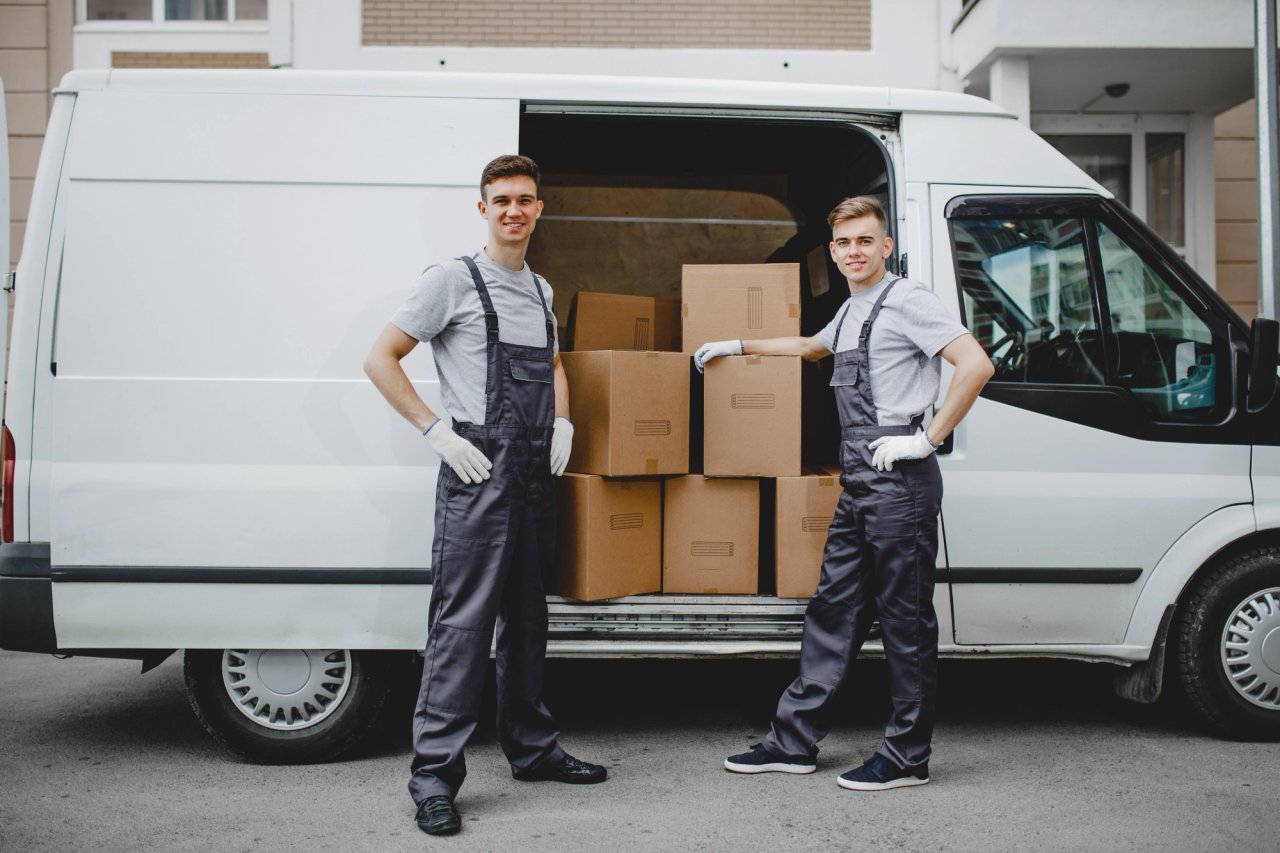 Two delivery men with packages at van for heavy goods delivery