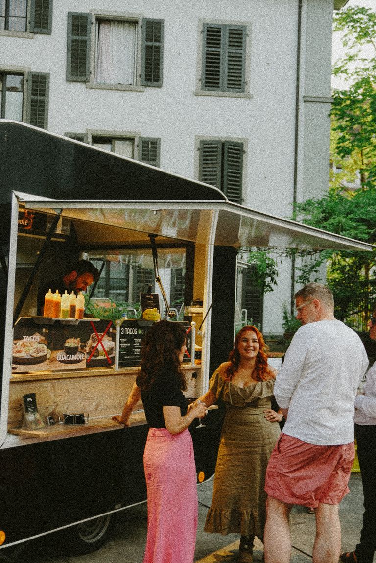 People talking in front of taco truck