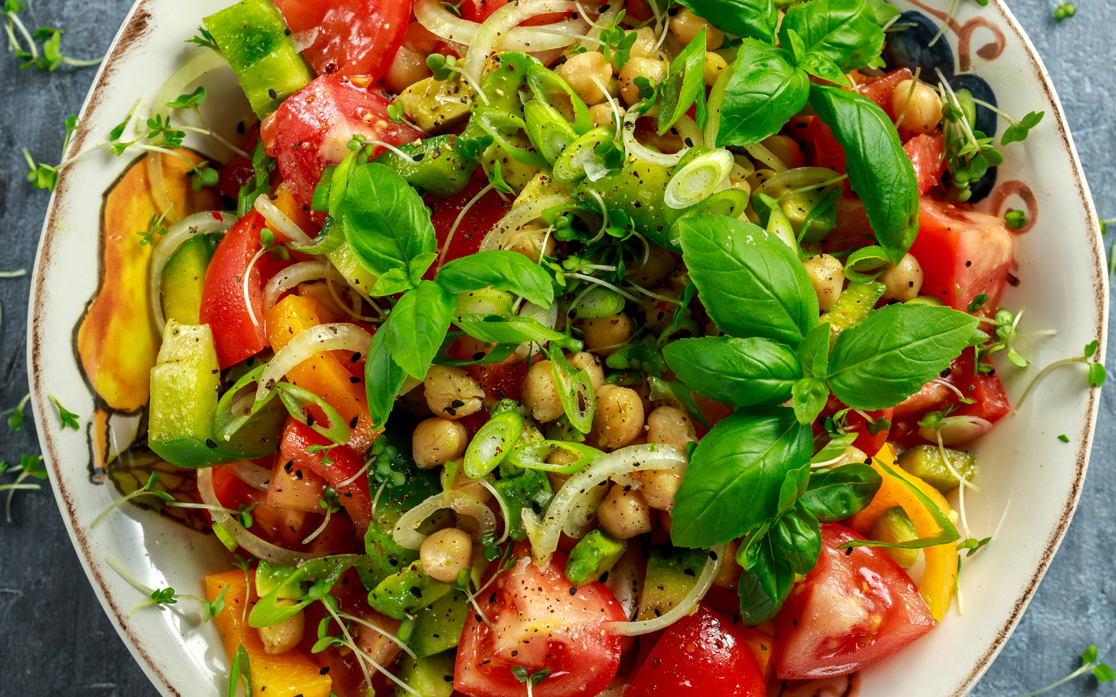 Zeytinyağlı nohut salatası tarifi için renkli sebzeler ve lezzetli zeytinlerle süslenmiş, sağlıklı ve besleyici bir salata kasesi