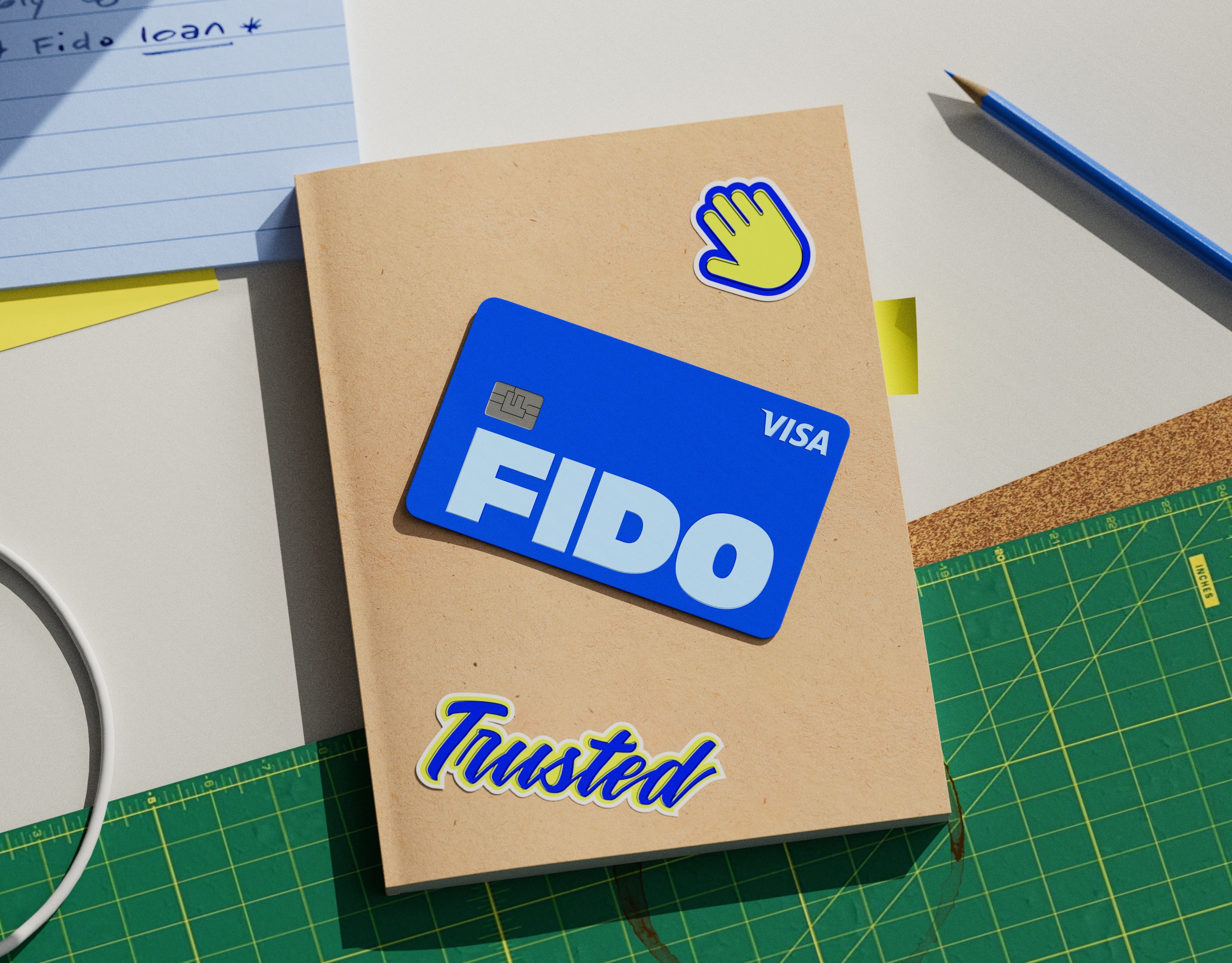 Fido debit card lying on a table surrounded by paper and pencils