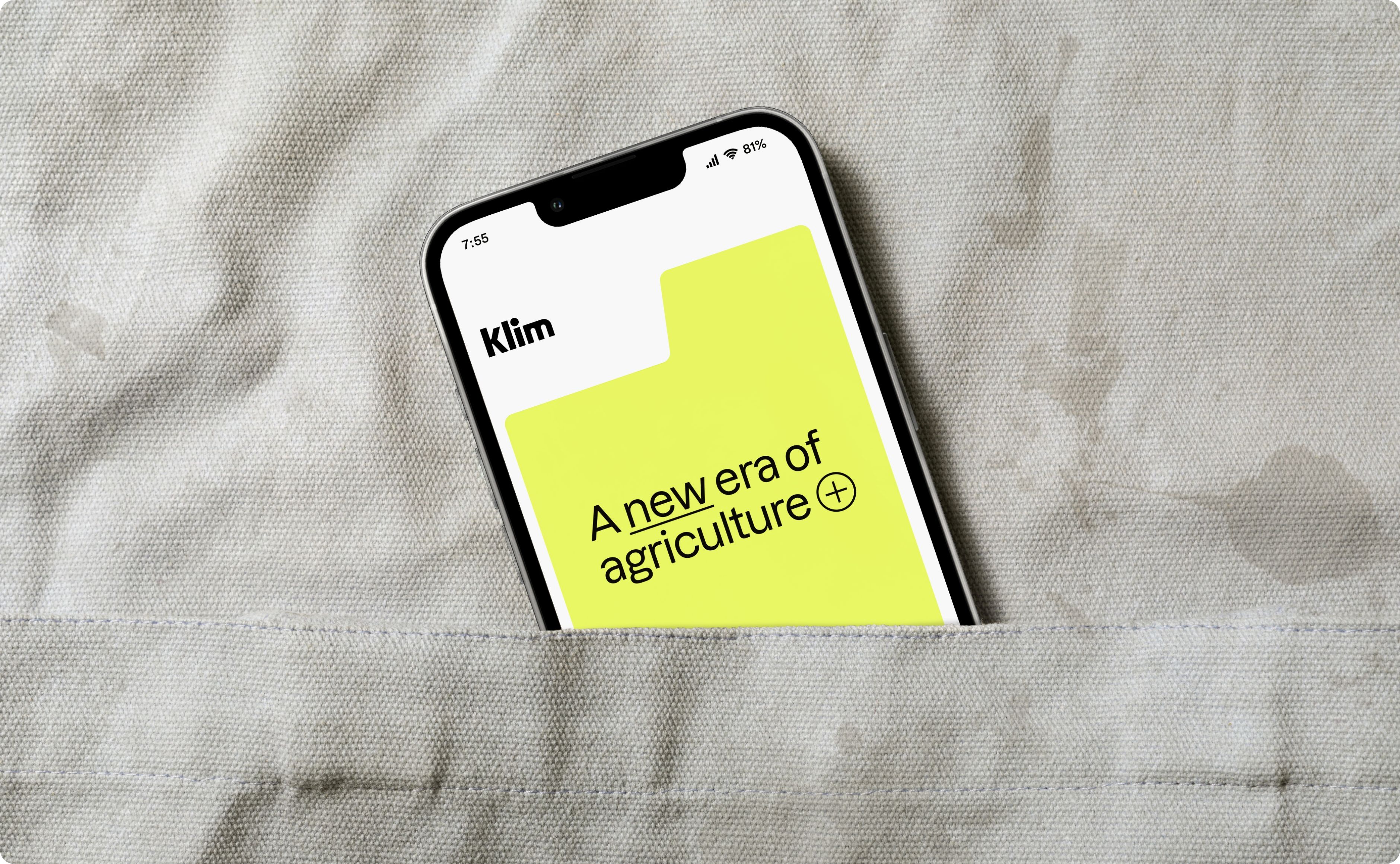 Phone tucked into an apron pocket showing Klim app splash screen.