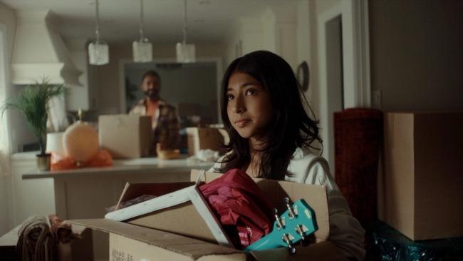 Young girl holding a box of her things