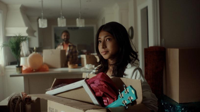 Young girl holding a box of her things